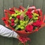 Hand holding a large red rose, pink lily and lime-green chrysanthemum bouquet with yellow solidago and fern in bold red and black striped wrap -- Blossom Surprise Northampton