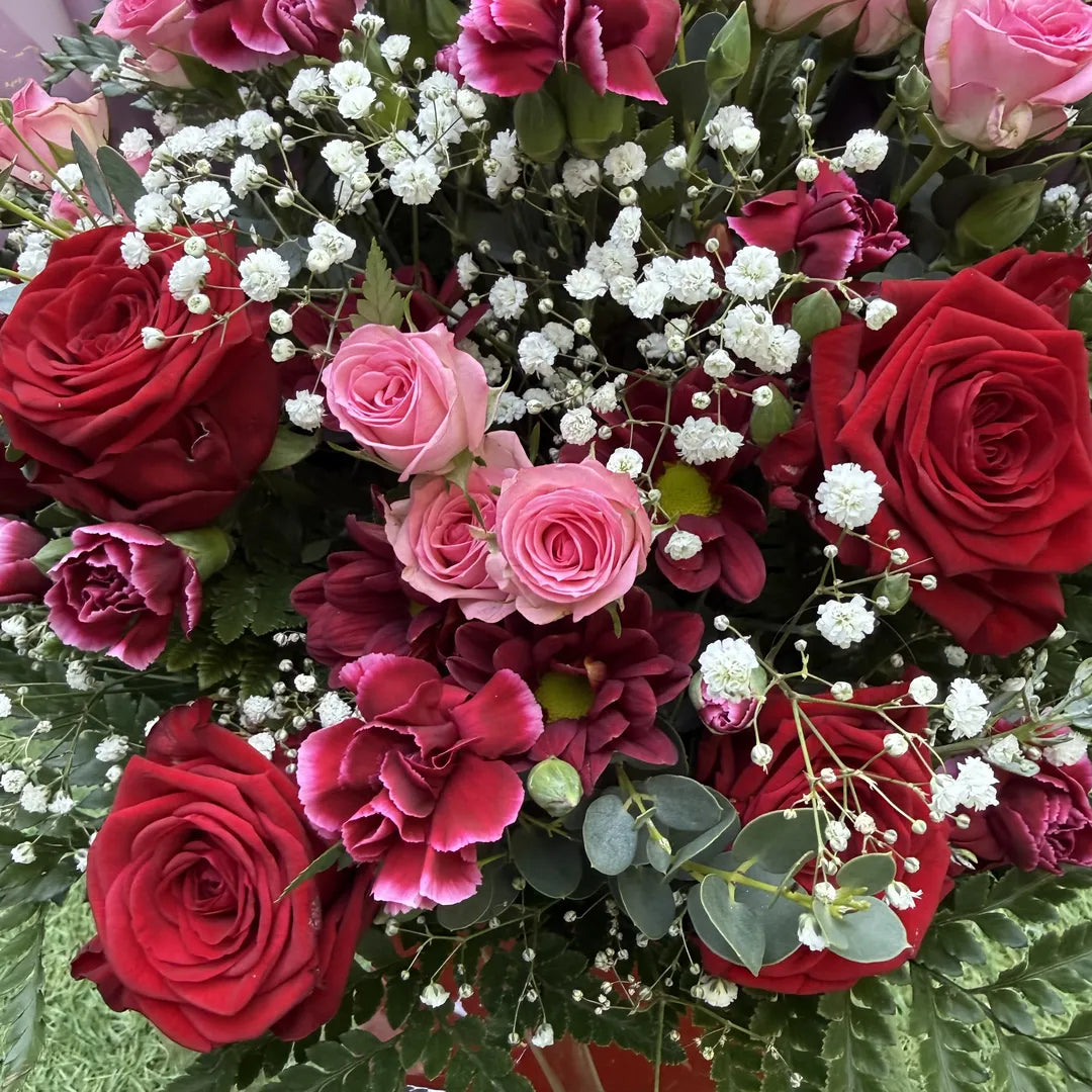 Macro detail of red rose, cerise carnation, pink spray rose and white gypsophila in a box bouquet arrangement -- Blossom Surprise Northampton