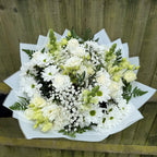 Overhead view of white flower bouquet with roses, lisianthus, chrysanthemums, green snapdragons and gypsophila in white paper wrap -- Blossom Surprise Northampton