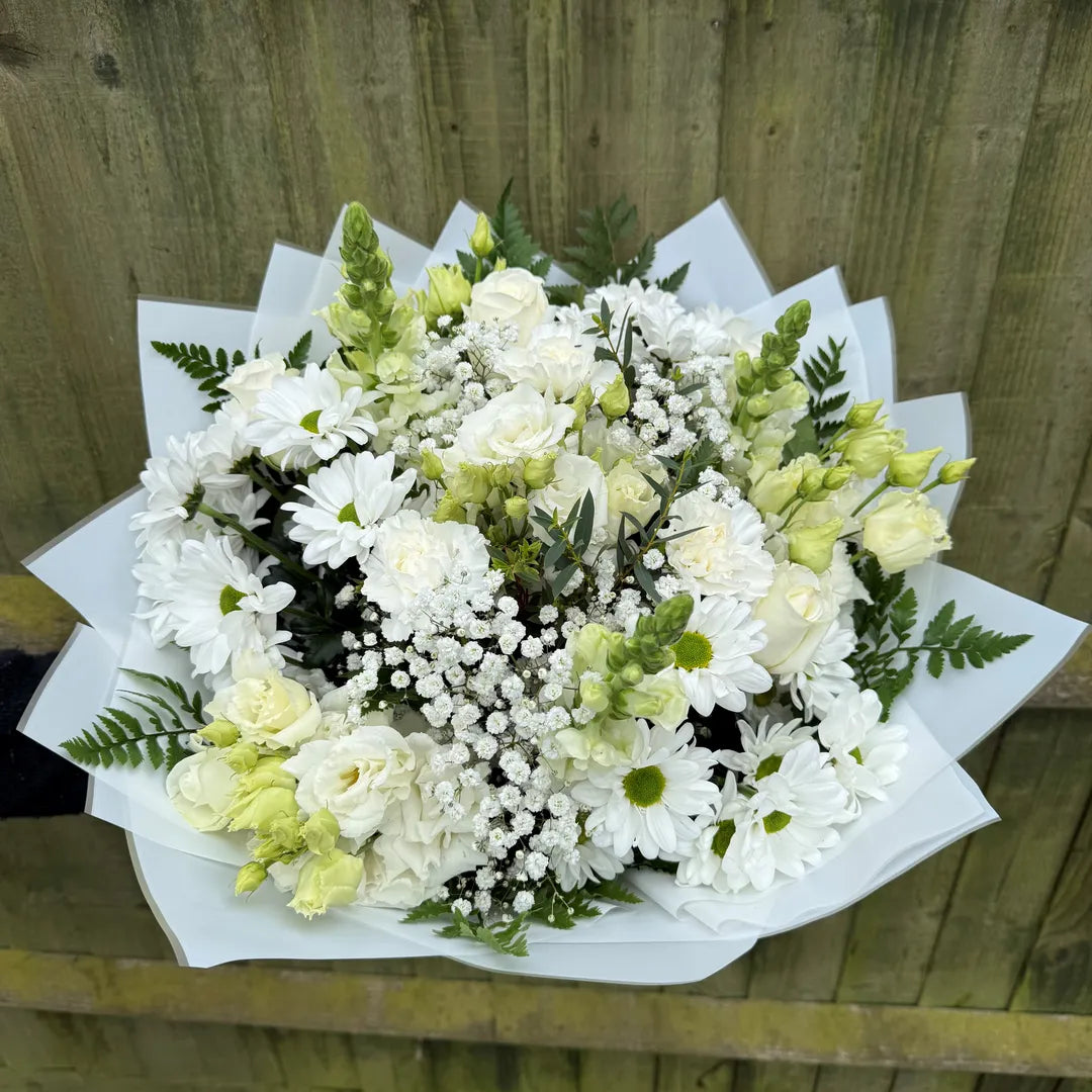 Overhead view of white flower bouquet with roses, lisianthus, chrysanthemums, green snapdragons and gypsophila in white paper wrap -- Blossom Surprise Northampton