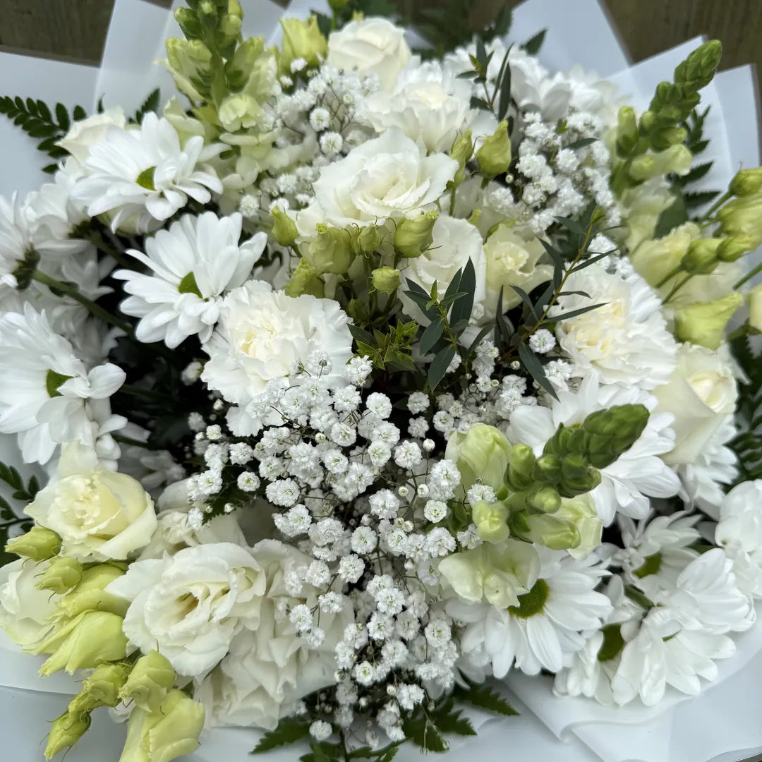 Detail of white bouquet showing white carnations, roses, lisianthus, chrysanthemums and eucalyptus hand-tied by Blossom Surprise Northampton florist