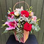 Flower gift bag arrangement with red roses, pink oriental lily, lisianthus and gypsophila in rose gold bag -- Blossom Surprise Northampton