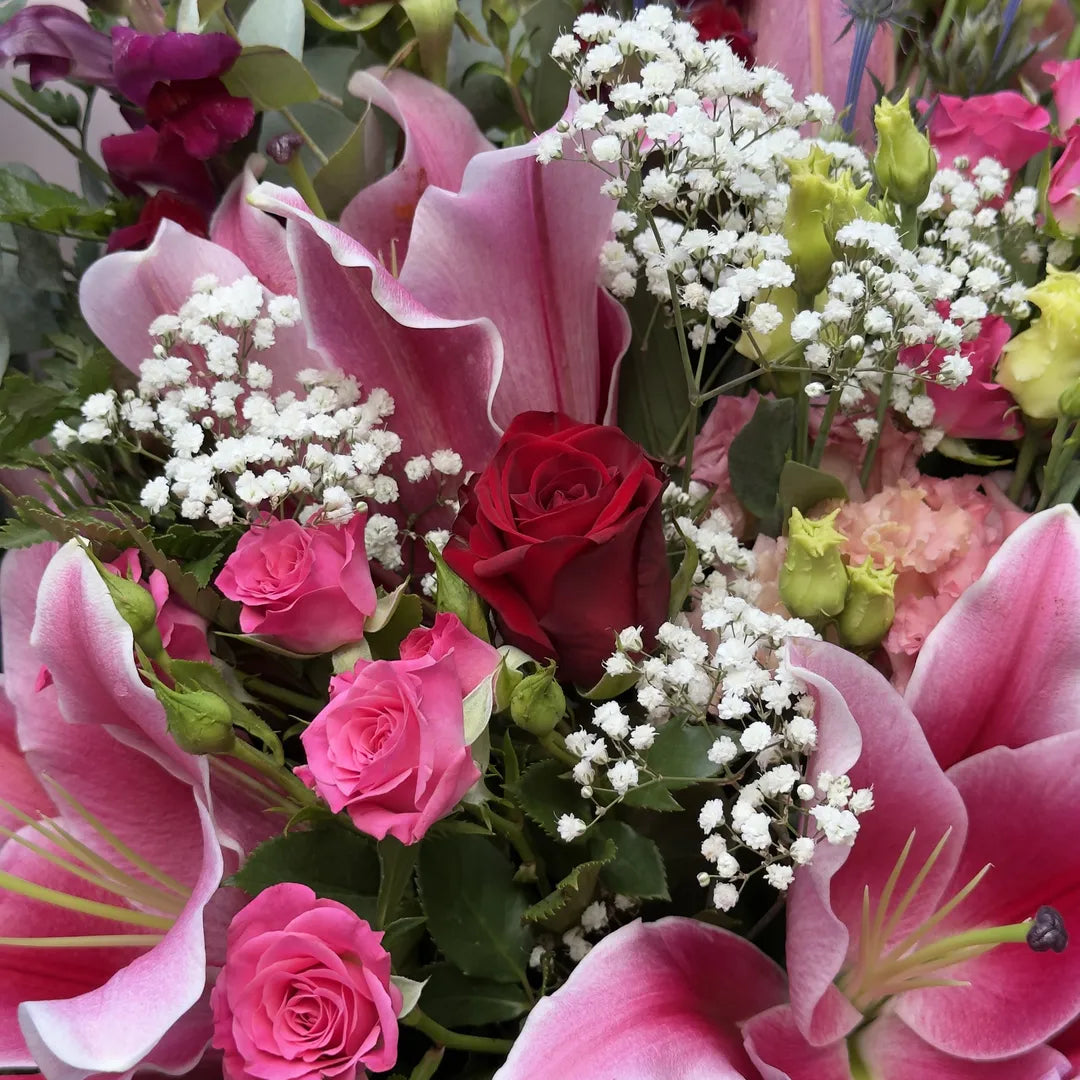 Close-up of open stargazer lily with red rose, pink spray roses and gypsophila -- Blossom Surprise Northampton