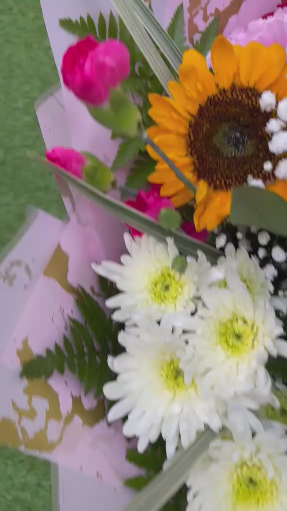 view of sunflower, rose and carnation bouquet with lily buds, white chrysanthemums and gypsophila in blush pink and gold wrap -- Blossom Surprise Northampton